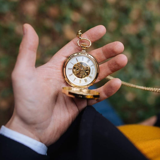Drevené vreckové hodinky Waidzeit Skelett Gold v ruke – elegantné hodinky pre gentlemana so zlatým puzdrom a orechovým drevom