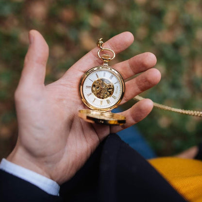 Drevené vreckové hodinky Waidzeit Skelett Gold v ruke – elegantné hodinky pre gentlemana so zlatým puzdrom a orechovým drevom